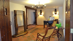 A room with a wooden door, a large mirror, a dining table with chairs, and a chandelier. - Hotel Casa La Fleur (Medellín)