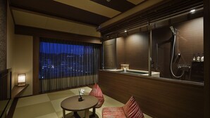 A modern hotel room with a large window, a round table, a sofa, and a built-in shower. - Laforet Ito Onsen Yunoniwa (Ito)