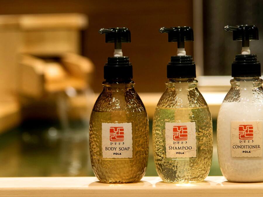 Three bottles of body care products on a wooden surface.