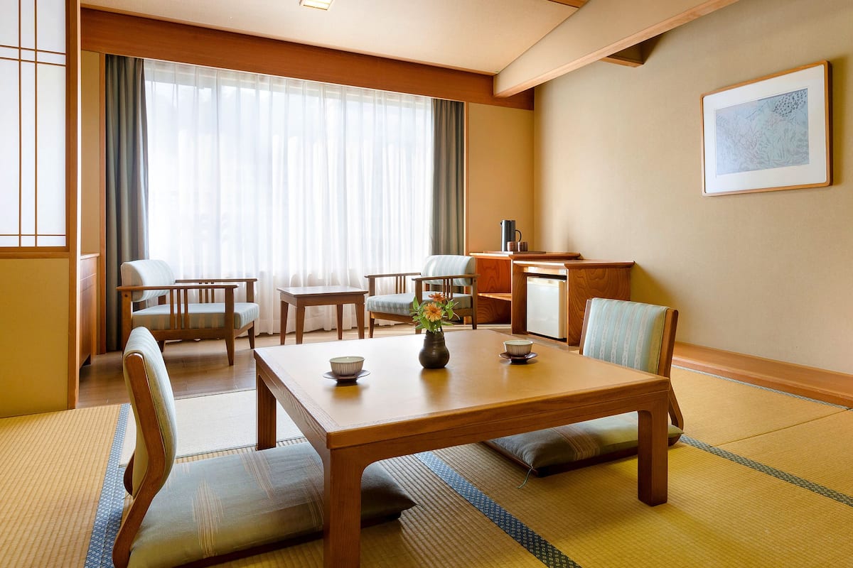 A traditional Japanese room with tatami flooring, a low wooden table, and simple furnishings.