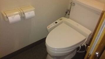 A standard white toilet with a control panel, a toilet paper holder with three rolls, and a visible toilet paper roll.