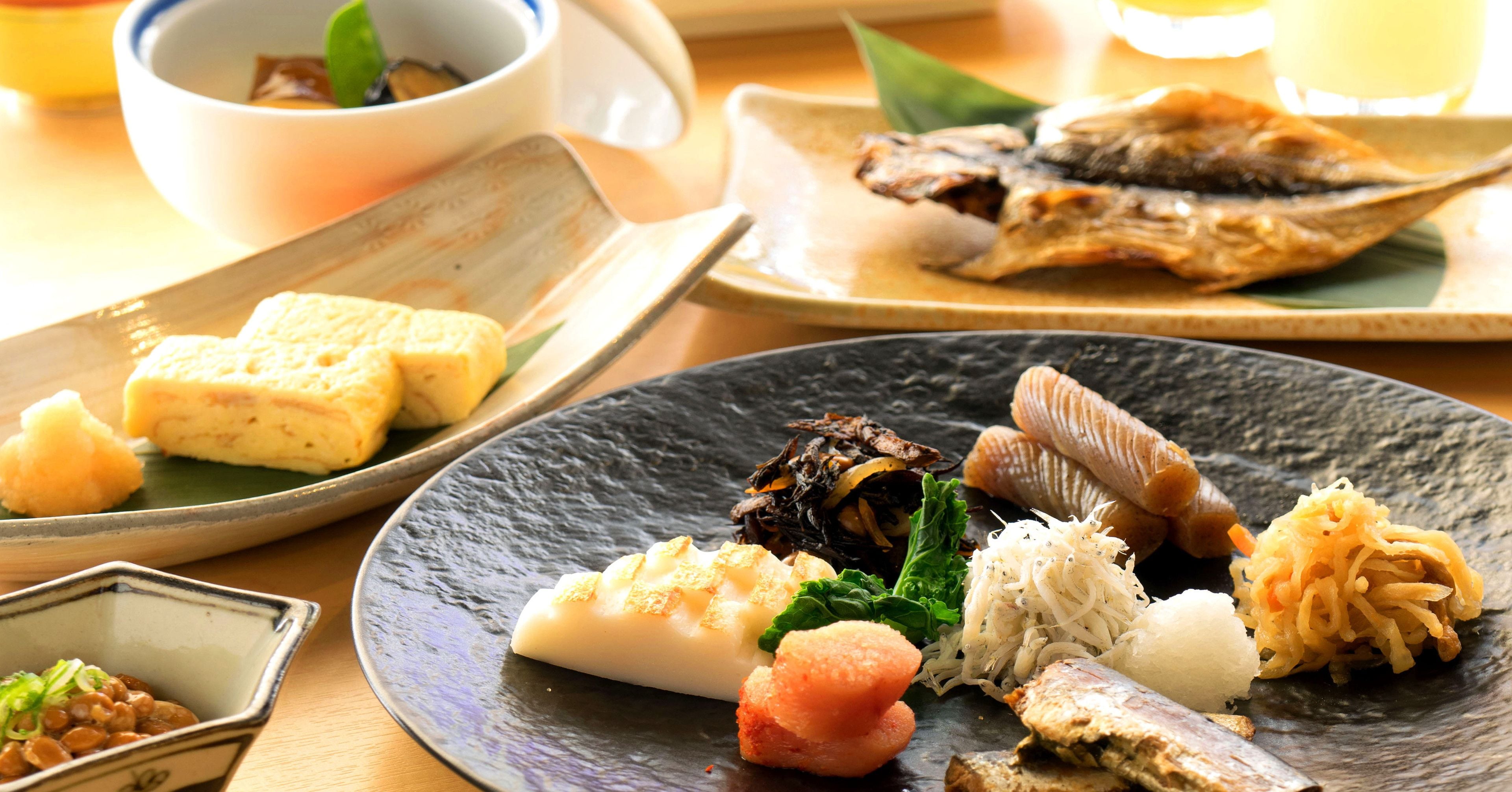 A variety of Japanese dishes on a table, including fish, tofu, and vegetables.
