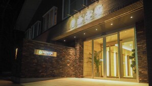 A hotel entrance with a brick facade, a signboard, and a glass door leading inside. - Hotel Grand Vert Kyukaruizawa (Karuizawa)