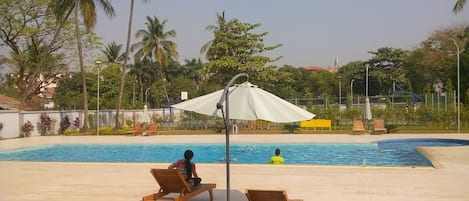 Piscine extérieure, parasols de plage, chaises longues