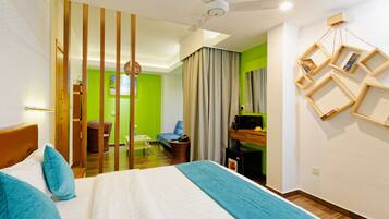Habitación de hotel con cama, escritorio, silla y una mesita.