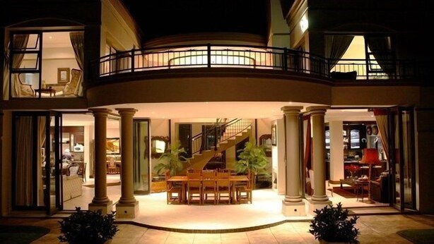 Une entrée imposante avec un escalier central, un coin repas et un balcon.