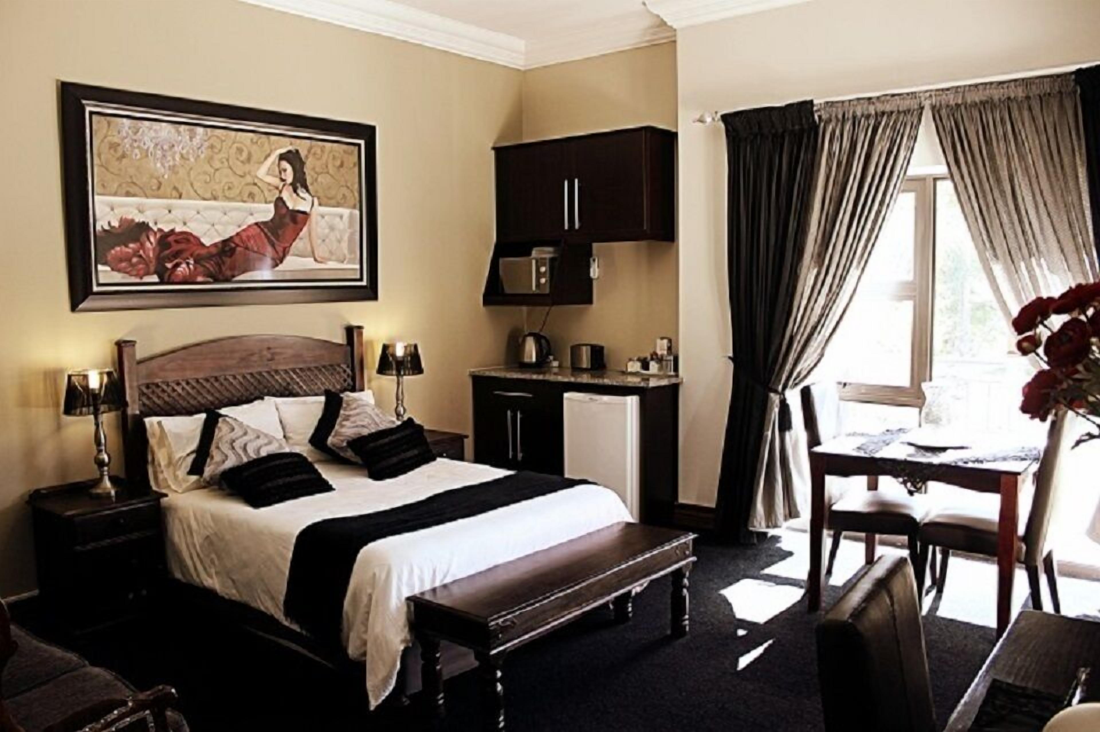 A hotel room with a large bed, bedside tables, a desk, and a chair.