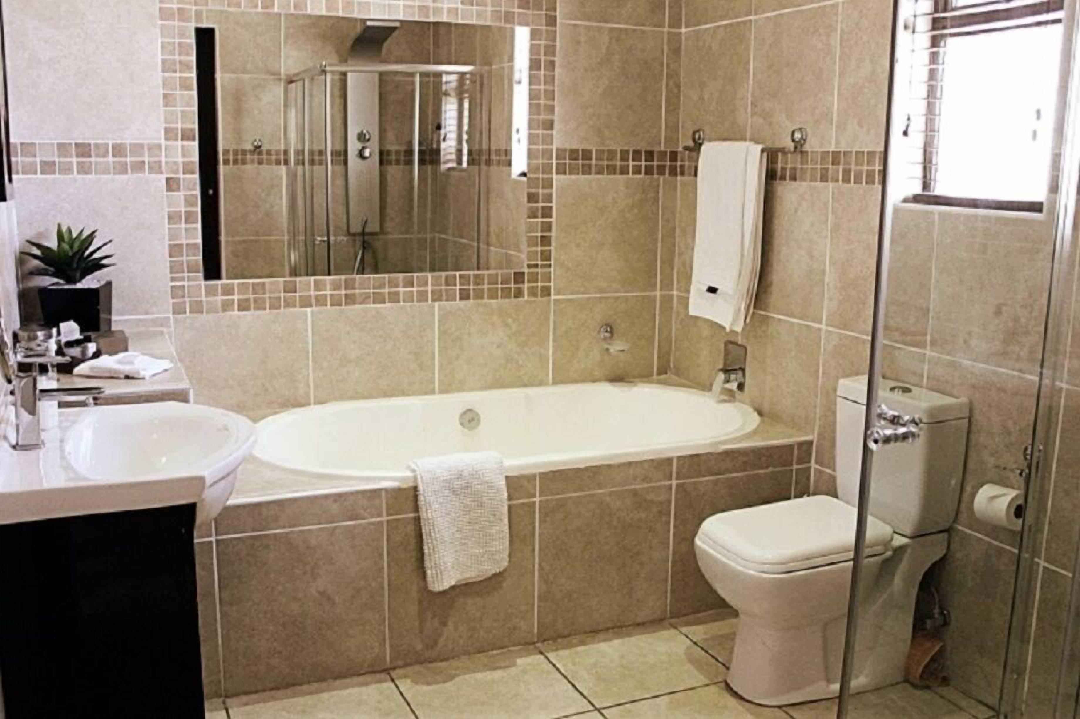 A modern bathroom with a bathtub, toilet, and sink.