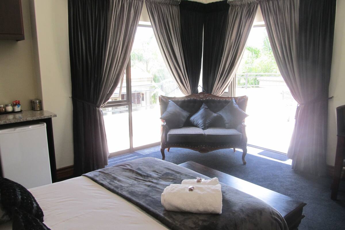 Ein Hotelzimmer mit Bett, Sofa und Blick ins Freie.