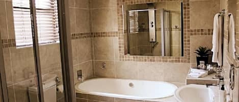A bathroom with a bathtub, a toilet, a sink, and a shower.