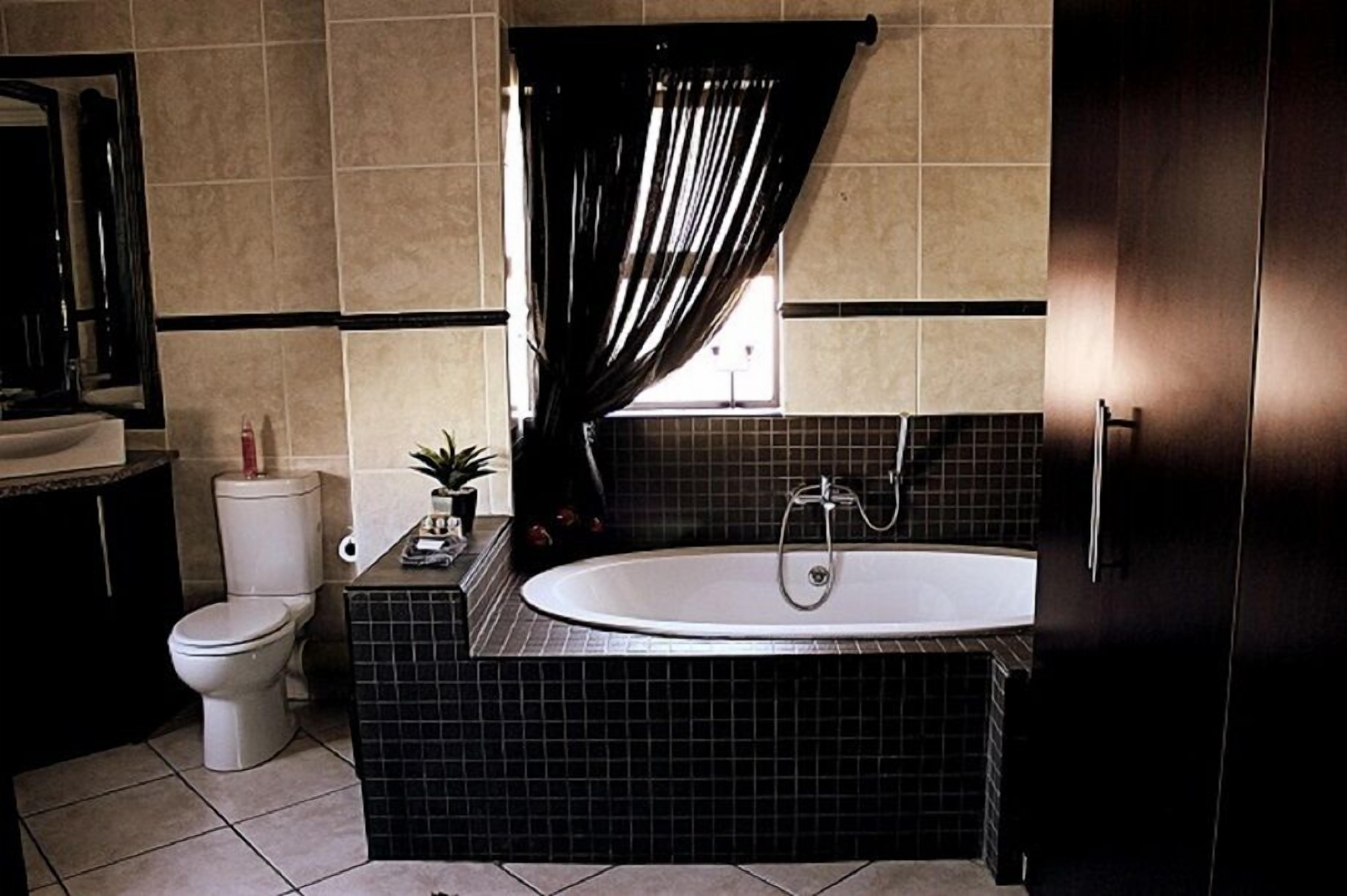 A bathroom with a bathtub, toilet, and sink.