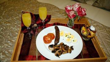 A tray with food and drinks on a bed.