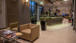 A modern reception area with a reception desk, seating, and a glass wall. - City Avenue (Tbilisi)