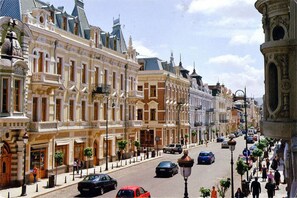 A street lined with historic buildings, a clear sky, and pedestrians. - City Avenue (Tbilisi)