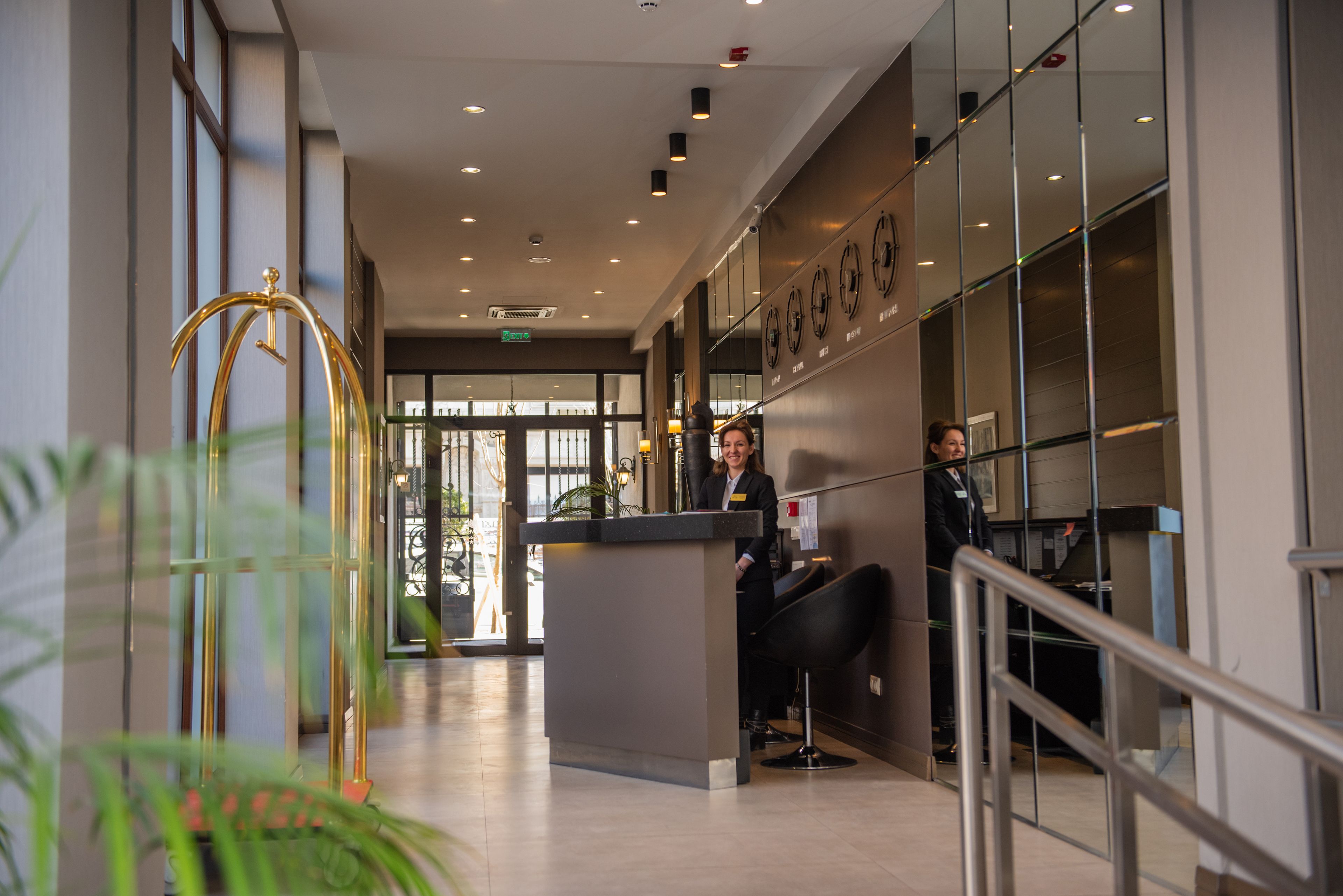 A reception area with a modern design, including a reception desk, seating, and a glass wall.
