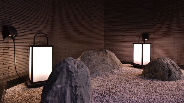 A room with a brick wall, two floor lamps, and large rocks on a pebble floor. - Urbain Kyoto Kiyomizu Gojo (Kyoto)