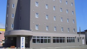 Um hotel de vários andares com design moderno, com um letreiro 'AXIS' em destaque no topo.