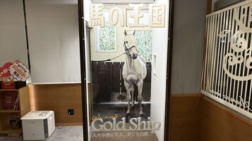 A room with a white horse statue, a Japanese sign, and a decorative screen.