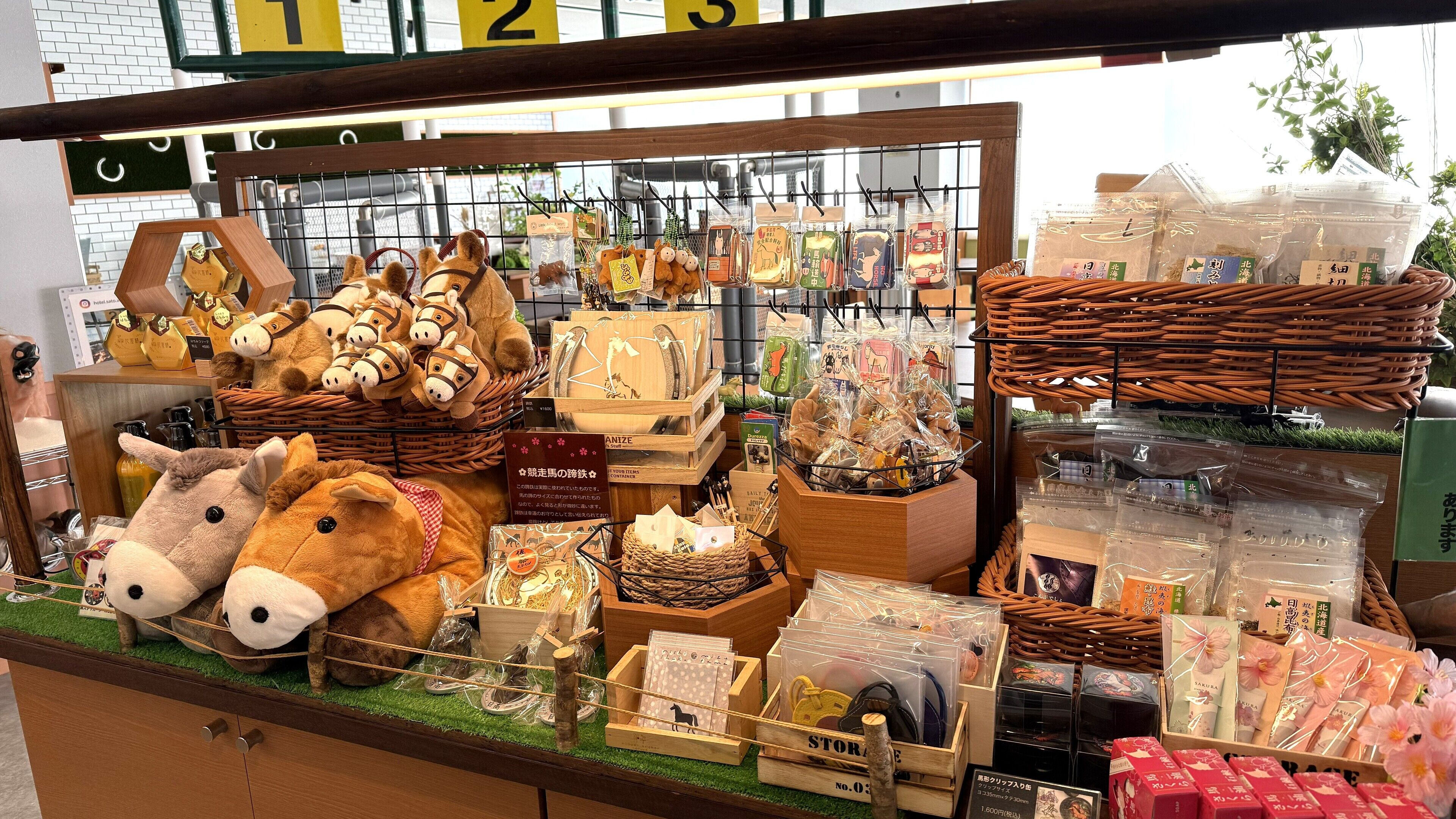 A display of various souvenirs and items, including plush toys, wooden crafts, and packaged goods, arranged on shelves and in baskets.