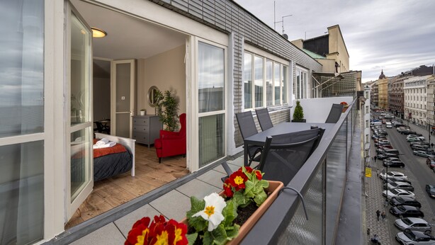 A balcony with a view of parked cars and a city street. - New Town - Apple Apartments (Prague)
