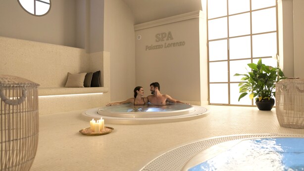 Ein Wellnessbereich mit Whirlpool, einer Sitzecke und einer Topfpflanze.
