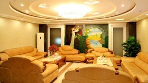 A well-lit living room with beige sofas, a coffee table, and a mural of a landscape. - Amore Hotel (Hanoi)