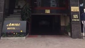 The exterior of Amore Hotel with a sign indicating the entrance and a visible entrance door. - Amore Hotel (Hanoi)