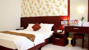 A hotel room with a bed, bedside table, desk, and a mirror. - Amore Hotel (Hanoi)