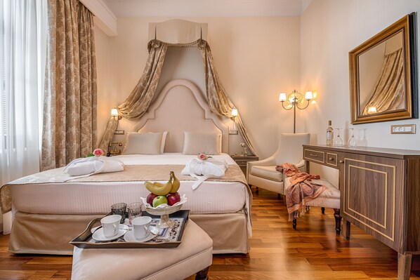 Una habitación de hotel con una cama grande, una mesita de noche, un escritorio y un armario.