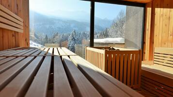 A wooden cabin with a large window overlooking a snowy mountain landscape.
