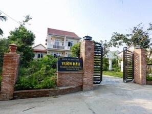 A gated entrance to a property named 'DICH VU LUU TRU' with a sign indicating it is a 'Strawberry Garden Hotel'. - Strawberry Garden Homestay (Da Nang)