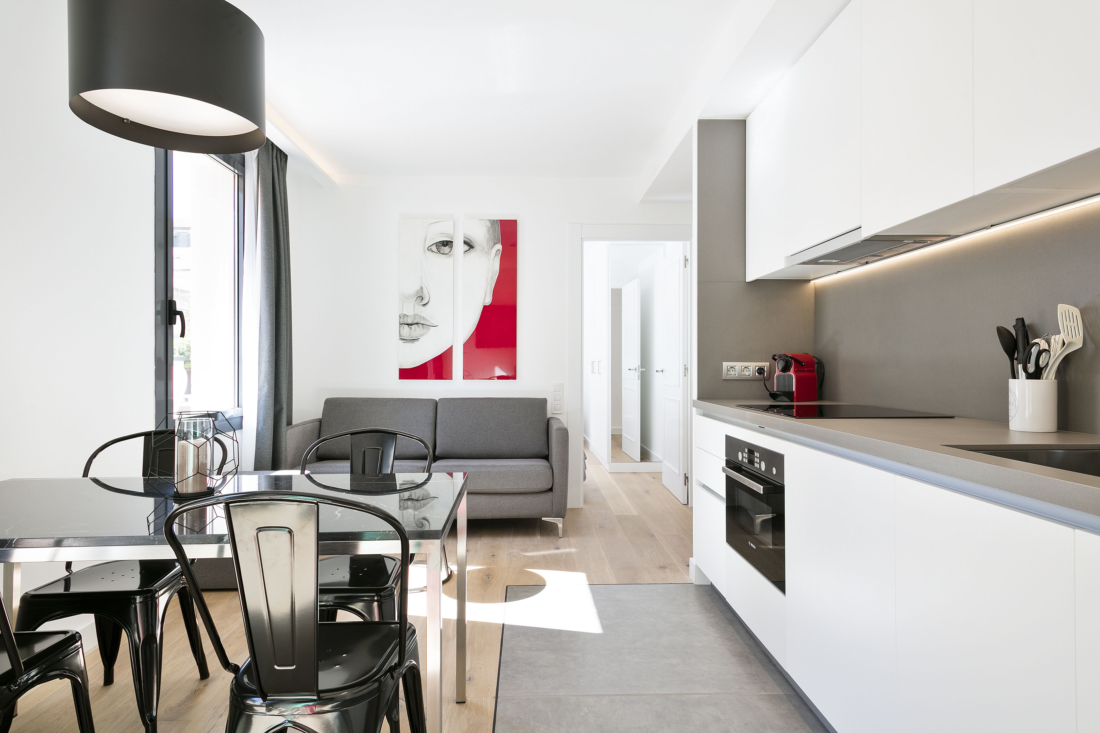 Una cucina moderna con zona pranzo, divano e una grande finestra.