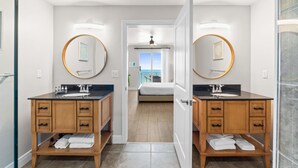 Une salle de bain moderne avec deux vasques, des meubles en bois et un grand miroir.