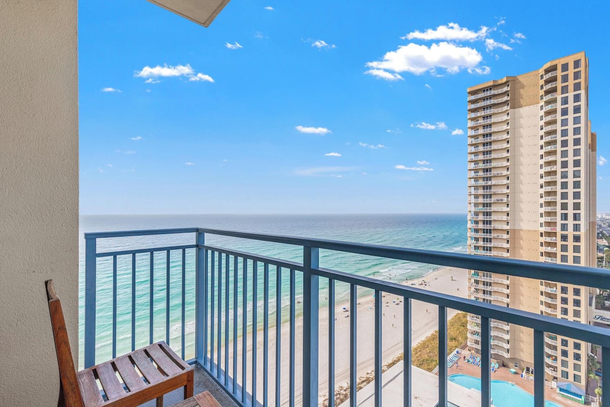 Ein Balkon mit Blick auf den Ozean und ein hohes Gebäude.