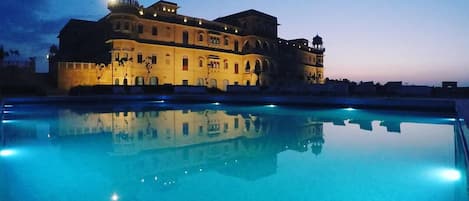 Una piscina al aire libre de temporada, sombrillas