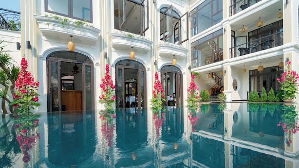 A multi-story building with a central pool, balconies, and outdoor plants. - Green Tea Homestay (Da Nang)