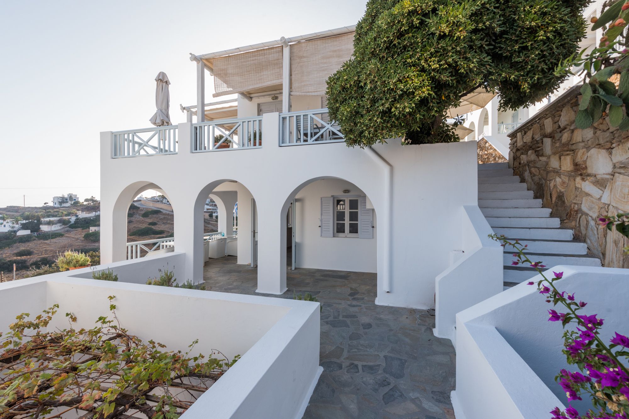 A white building with multiple arches and a stone staircase.