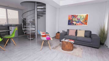 Una sala de estar moderna con un sofá gris, una silla colorida, una escalera de caracol y un cuadro en la pared.