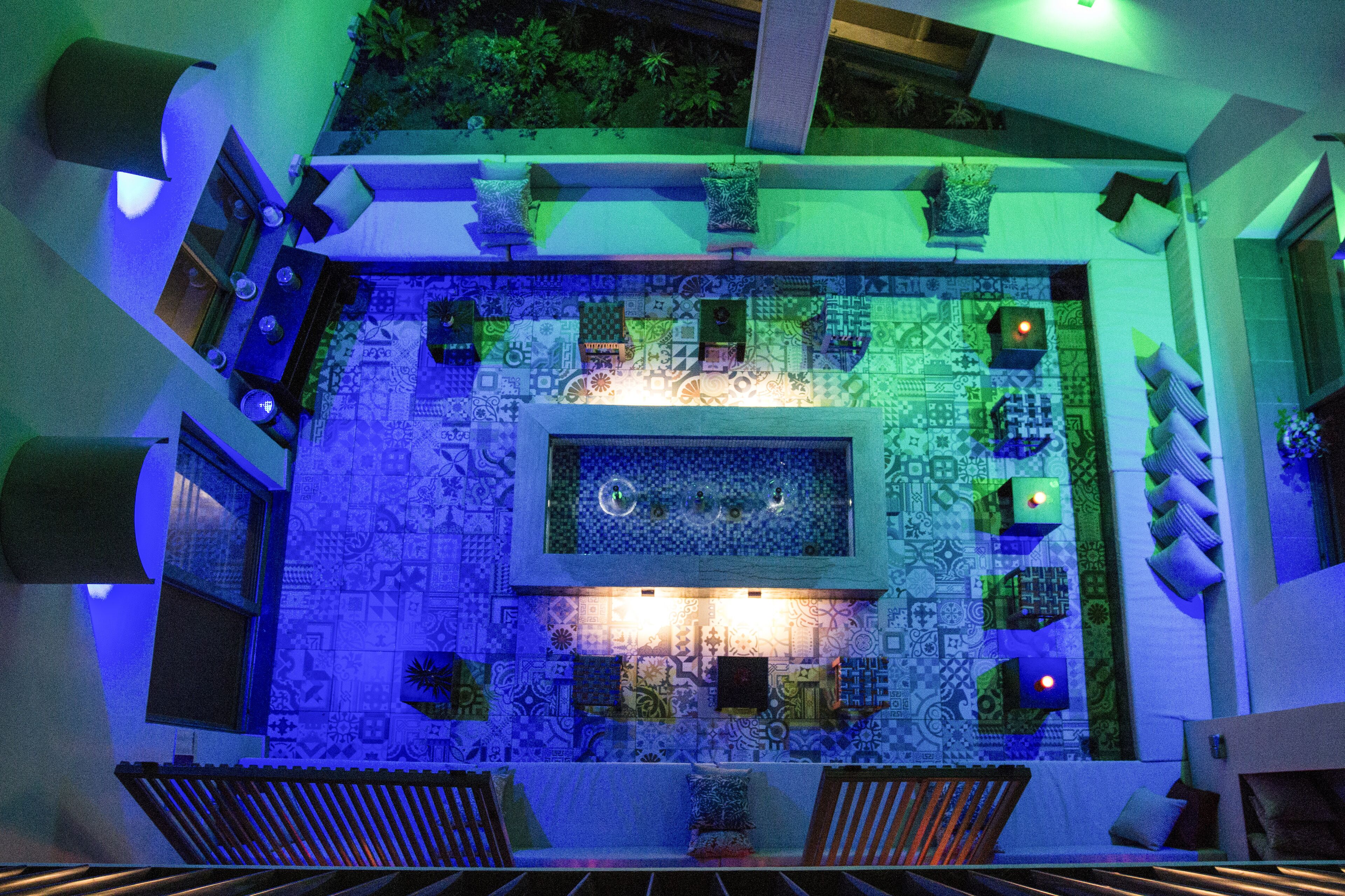 Terraza en la azotea con suelo estampado, zona de estar y una fuente central.