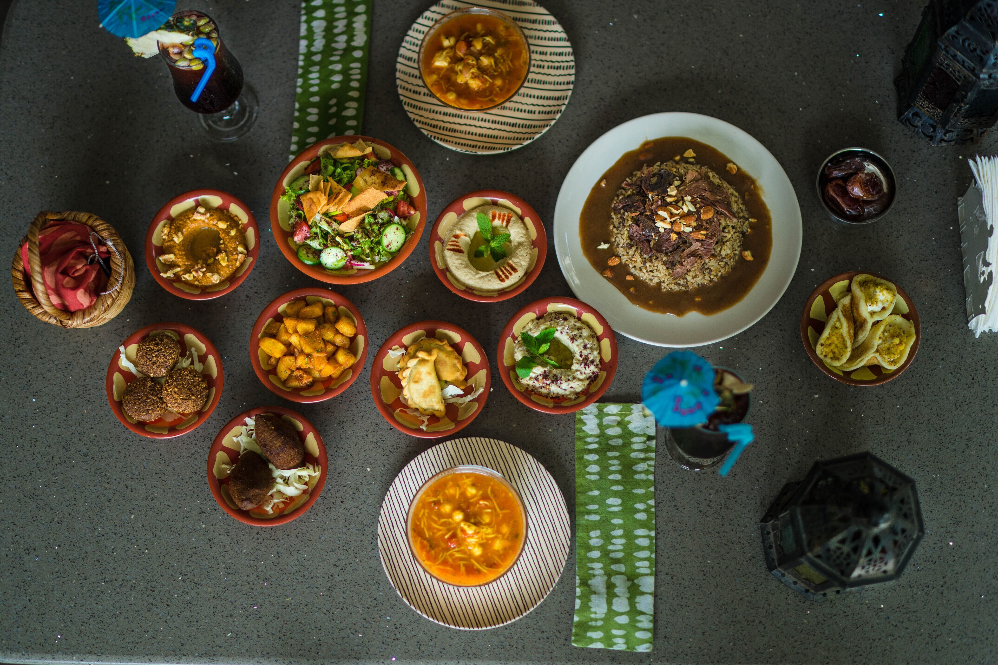 Une variété de plats disposés sur une table, notamment des bols de soupe, des salades et d’autres aliments.
