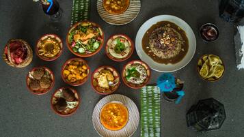 Une variété de plats disposés sur une table, notamment des bols de soupe, des salades et d’autres aliments.