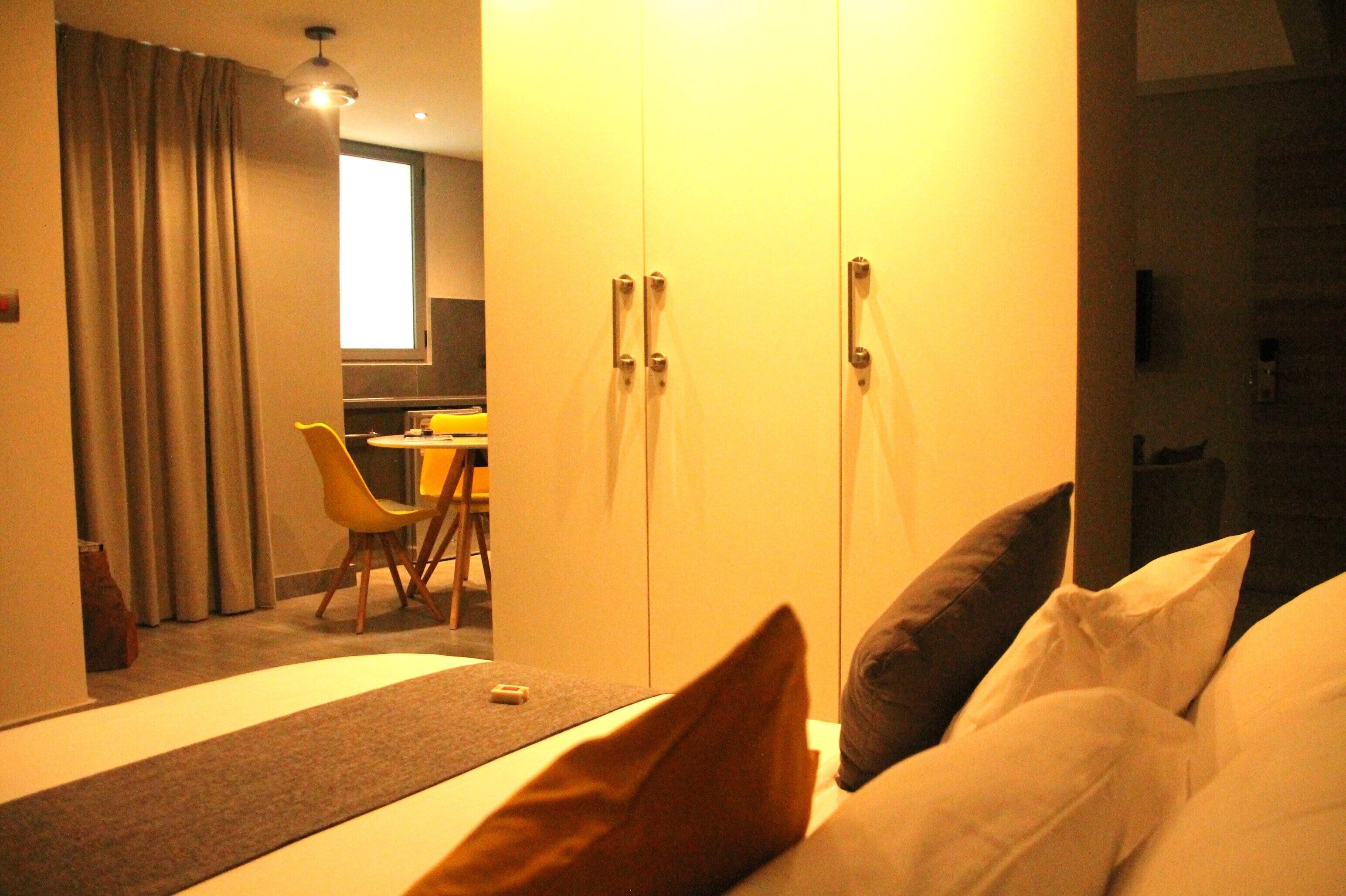 Ein Hotelzimmer mit Bett, Kissen, Schreibtisch und Stuhl.