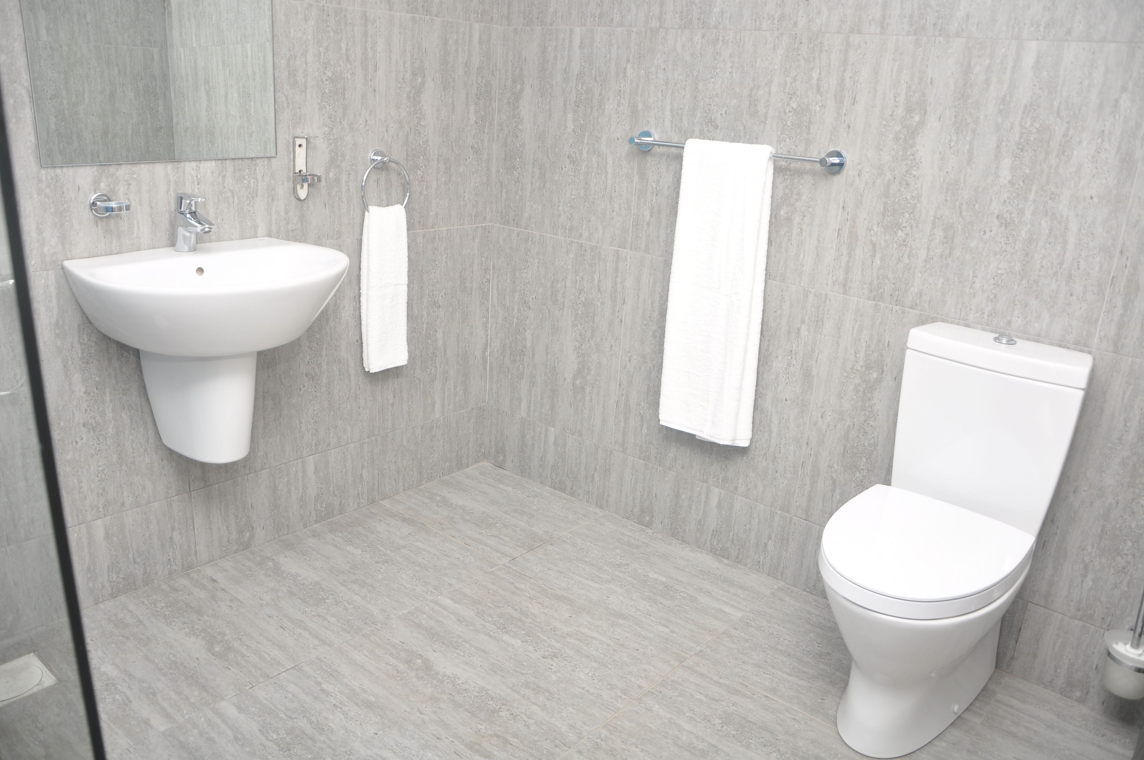 Ein modernes Badezimmer mit Waschbecken, Toilette und Handtuchhalter.