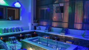 A modern lounge area with a seating arrangement, a small pool, and ambient lighting. - Urbano Hotel (Accra)