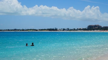 Playa en los alrededores, playa de arena blanca, camastros y sombrillas 