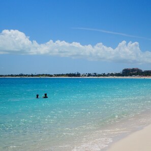 Ranta lähistöllä, valkoista hiekkaa, aurinkotuoleja, aurinkovarjoja