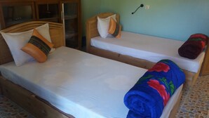 A room with two wooden beds, each with a pillow and a blanket. - Hostel Roma Inn 2 (Kalaw)