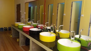A row of sinks with mirrors, each with a different colored basin. - Hostel Roma Inn 2 (Kalaw)
