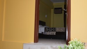 Eine Treppe führt zu einem Schlafzimmer mit einem Bett und einem kleinen Wandheizgerät.