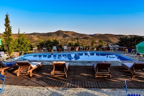 Seasonal outdoor pool, open 10:00 AM to 10:00 PM, pool umbrellas